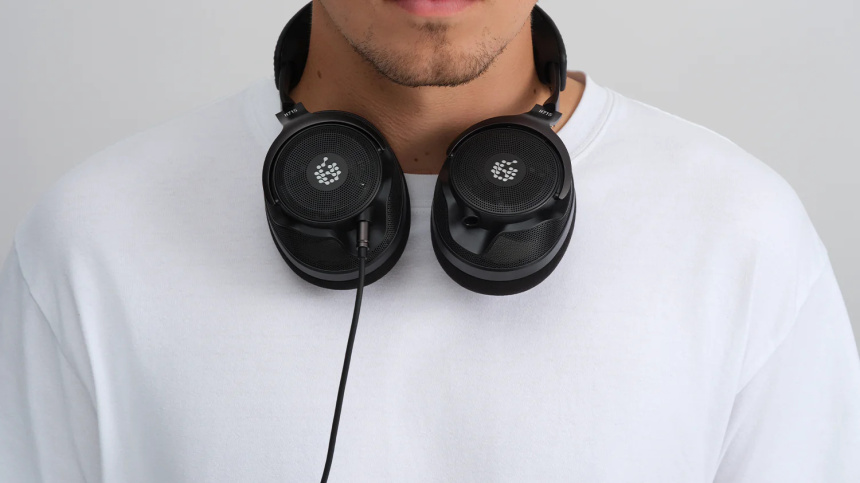 Persona con los auriculares H715 Reference colgados del cuello y cable conectado a la copa izquierda.