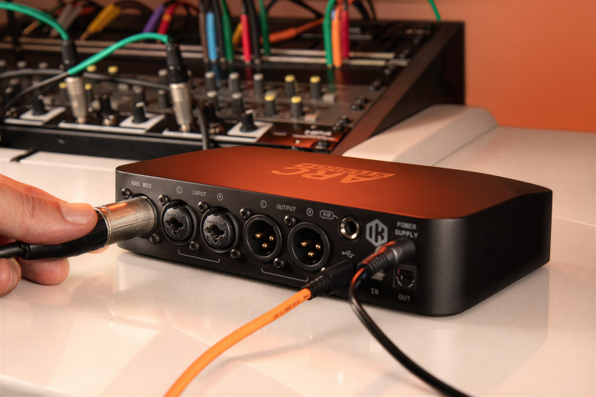 Panel trasero del ARC Studio+ donde una mano conecta un cable XLR a las tomas combo